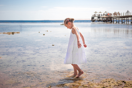 LIttle girl playing near waterの写真素材