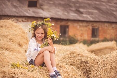 Sisters sitting on haystackの写真素材