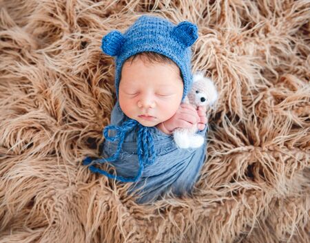Newborn boy wrapped in a blanketの写真素材