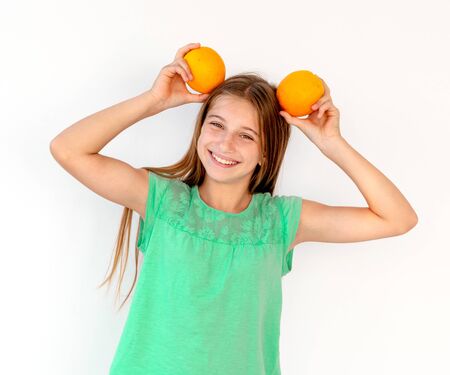 Little girl with fresh orange fruitsの写真素材
