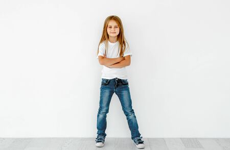 Cute little girl with crossed hands isolated on whiteの写真素材