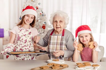 Grandmother with granddaughters baking cookiesの写真素材