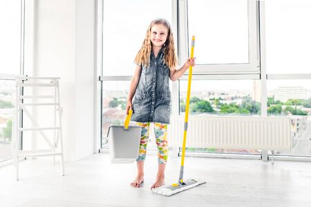 Little girl moping floor in the living roomの写真素材