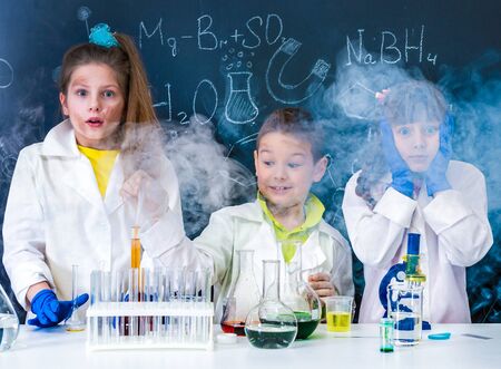 three excited children after chemical experimentの写真素材