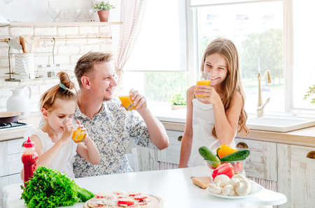 dad with daughters preparing pizzaの写真素材