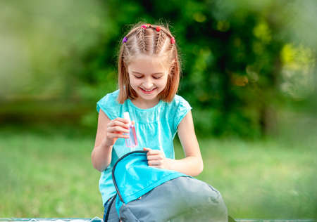 Little girl taking out mask from backpack