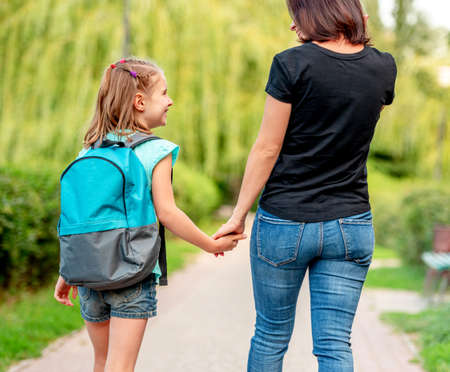 Schoolgirl going home with mother