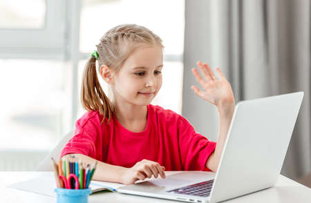 Little girl talking online using laptop