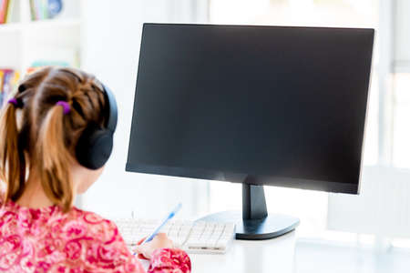 Happy little girl looking at computer screen