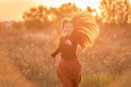 Happy teenage girl walking in autumn natureの写真素材