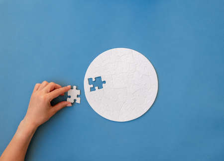 Hand putting piece in round puzzleの写真素材
