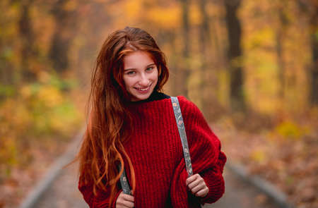 Young girl posing on autumn park roadの写真素材