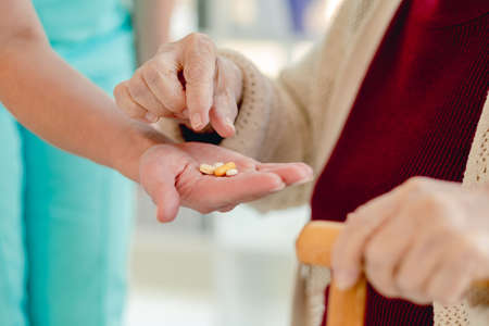Nurse giving pills to woman patientの写真素材
