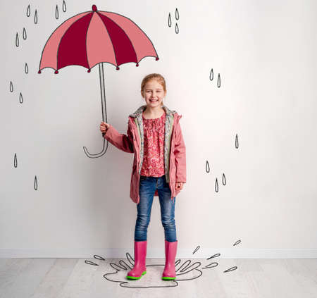 Little girl hiding under umbrella drawnの写真素材