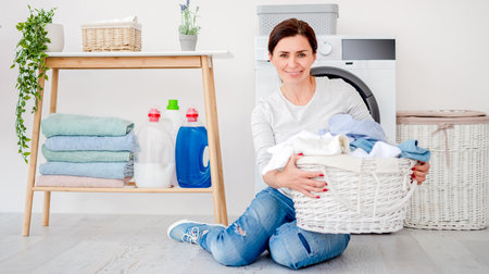 Woman with laundry basket sitting on floor
