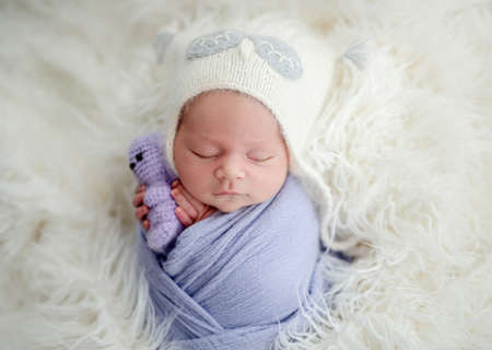 Newborn with toy in tiny handsの写真素材