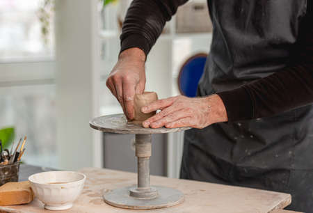 Man using pottery wheel for molding