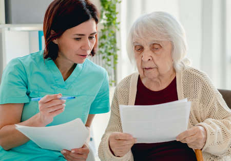 Nurse talking with elderly woman patient