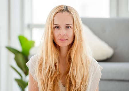 Portrait of pretty attractive blond girl without makeup at home.の写真素材