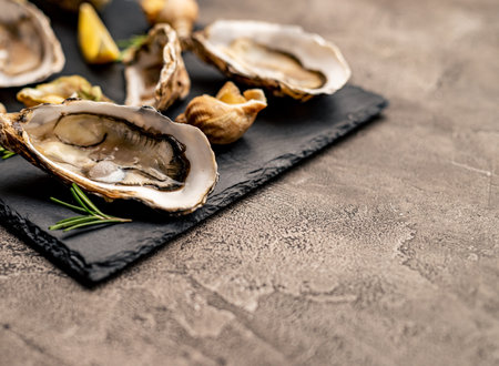 Set of oysters and snails on black platterの写真素材