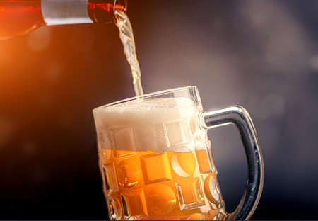 Pouring beer from a bottleの写真素材