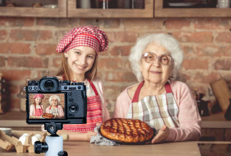 Granddaughter and her granny with fruit pie