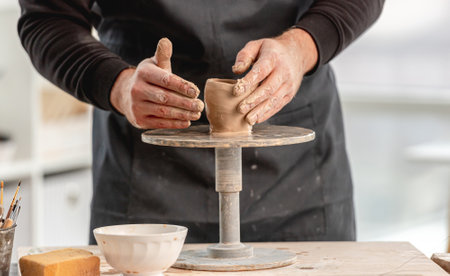 Man using pottery wheel for moldingの写真素材