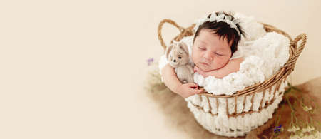 Funny newborn in basket on stomachの写真素材