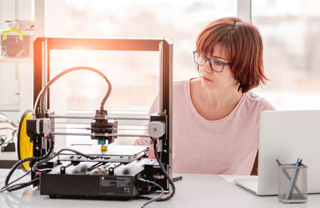 Woman working with 3D printer
