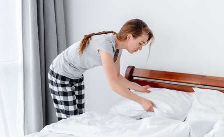 Girl making the bedの写真素材