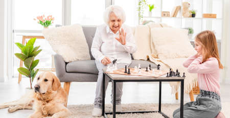 Girl playing chess with grandmotherの写真素材