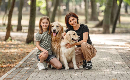 Mother and daughter with golden retriever dogの写真素材