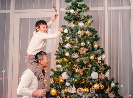 Son and father putting star on treeの写真素材