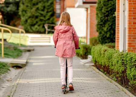 Funny little girl rides a kick scooterの写真素材