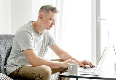 young handsome man works at a laptop