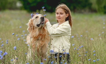 Preteen girl with golden retriever outdoorsの写真素材