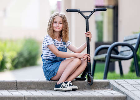 Little girl rides a kick scooterの写真素材