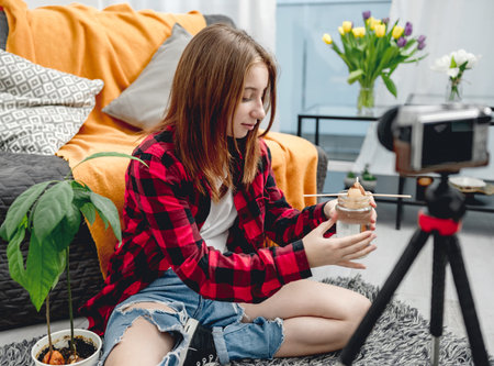 Pretty girl teenager teaching how to grow avocadoの写真素材