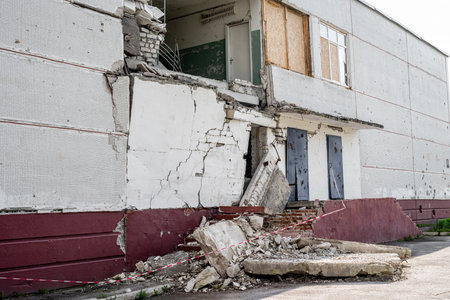 Destroyed residential building wall after russian missle rocket attack during war in Ukraine. Ruins in city Kharkiv after enemy military invasionの写真素材