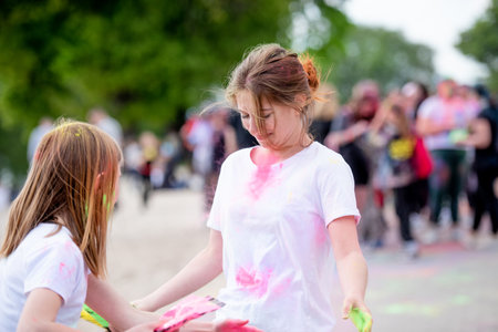 Pretty sisters in indian traditional Holi festival with colorful powder having fun. Female teenager and preteen child friends enjoying holidayの写真素材