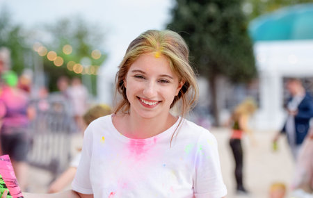 Pretty girls in indian traditional Holi festival with colorful powder having fun. Female teenager and preteen child enjoying positive holiday of Indiaの写真素材