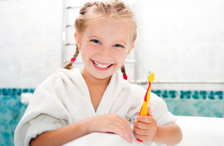 Little girl brushing teeth in bathの写真素材