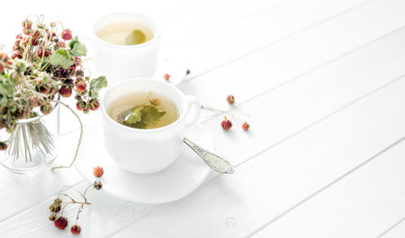 Two cups of strawberry tea on a wooden backgroundの写真素材