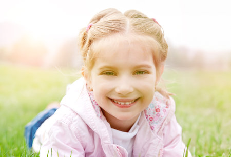 Cute little girl on the meadow in spring dayの写真素材