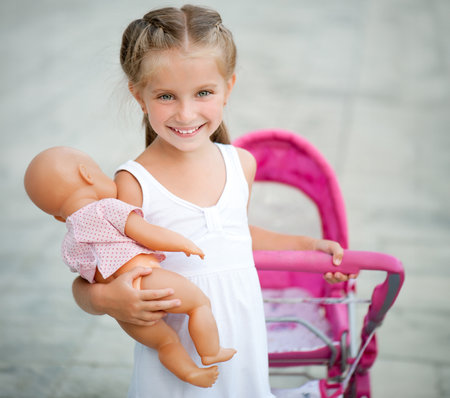 Cute little girl with her toy carriageの写真素材