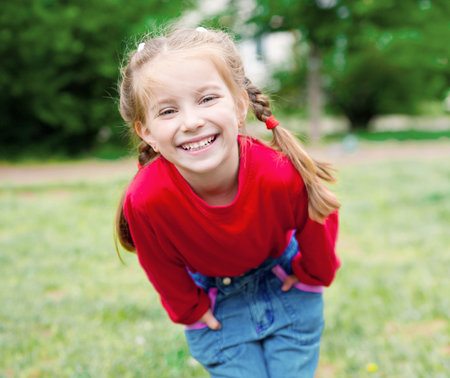 Cute little girl on the meadow in summer dayの写真素材