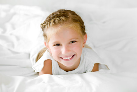 Adorable little girl wake up in her bedの写真素材