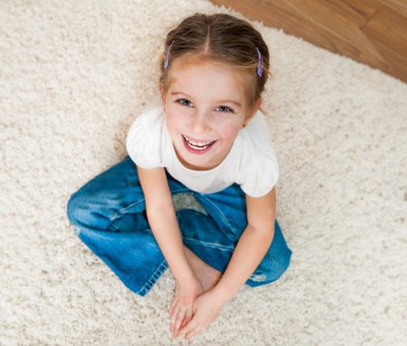 cute little girl sitting on the floorの写真素材