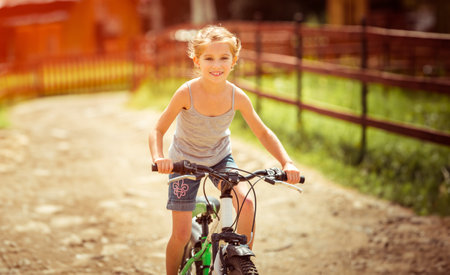 little girl riding a bicycle in rural areasの写真素材