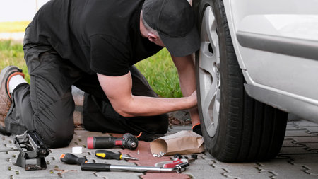Driver Repairs Car Using Tools On Streetの写真素材